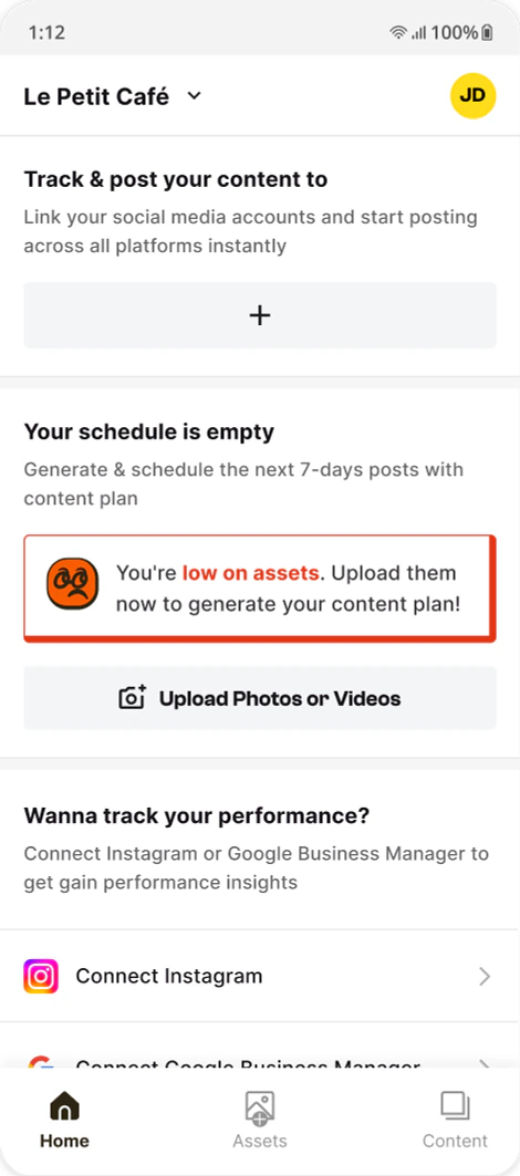 Home screen of the early app: an empty schedule and a “low on assets” alert with an Upload Photos or Videos button.